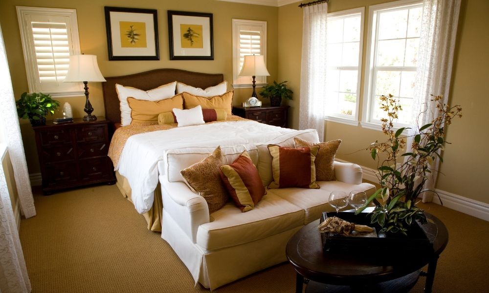 A bedroom with bed adjacent sofa