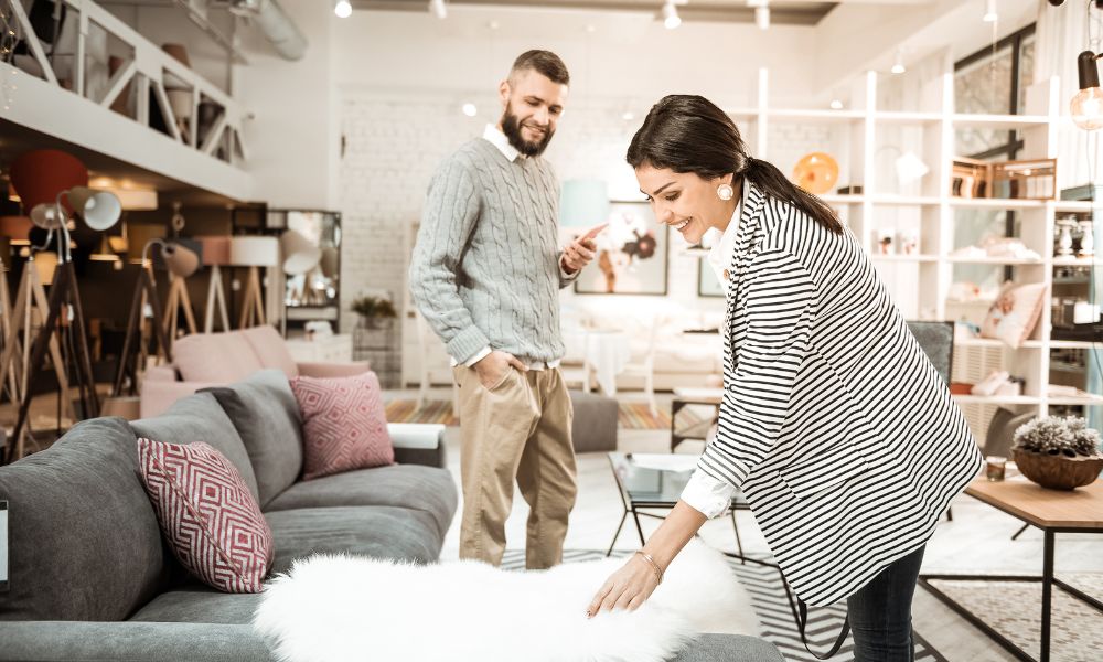 a couple shopping sofa and a lady touching the sofa gently